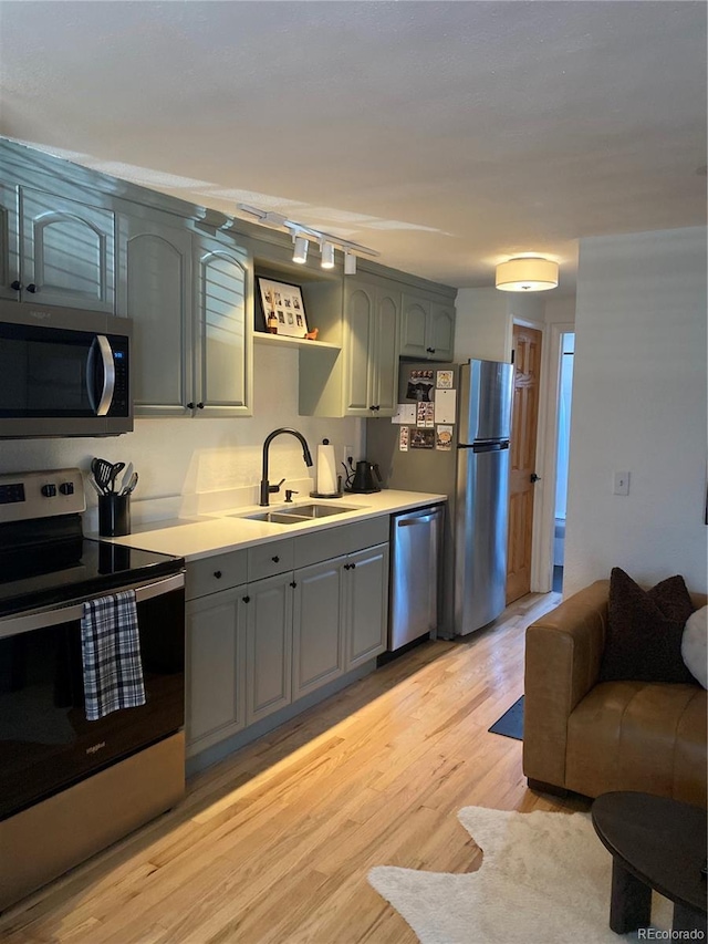 155 S Pennsylvania St Unit 209, Denver, CO 80209 - kitchen with appliances with stainless steel finishes, gray cabinets, light wood-style floors, and light countertops