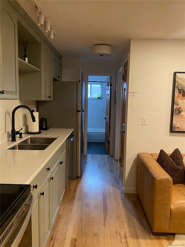 155 S Pennsylvania St Unit 209, Denver, CO 80209 - kitchen with appliances with stainless steel finishes, light wood-style flooring, light countertops, open shelves, and a textured wall