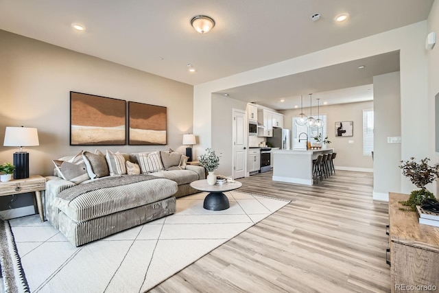 living room featuring sink and light hardwood / wood-style floors