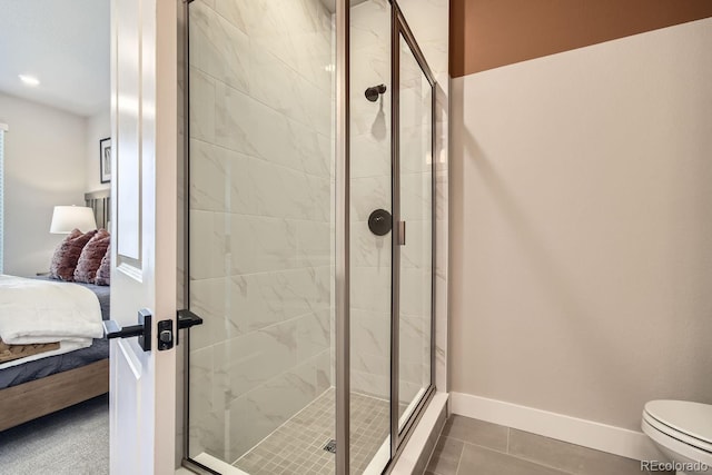 bathroom with an enclosed shower, toilet, and tile patterned flooring