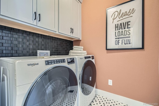 laundry room with washing machine and dryer and cabinets