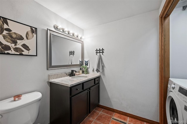 bathroom featuring tile patterned flooring, toilet, visible vents, vanity, and washer / dryer