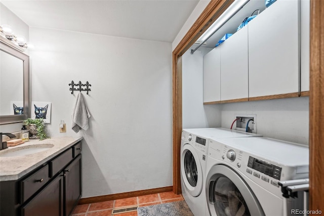 laundry room with light tile patterned floors, visible vents, a sink, separate washer and dryer, and baseboards