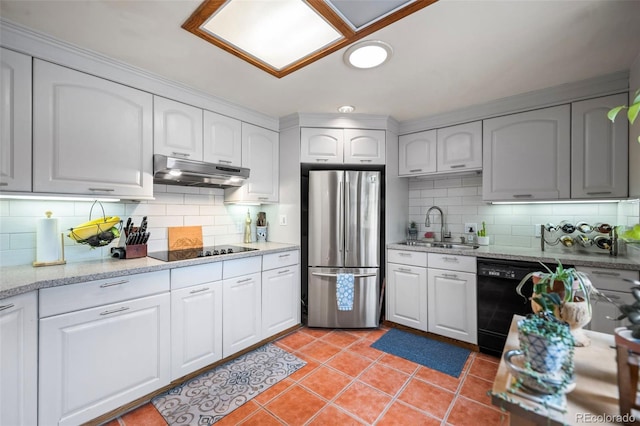 kitchen with tasteful backsplash, a sink, under cabinet range hood, and black appliances