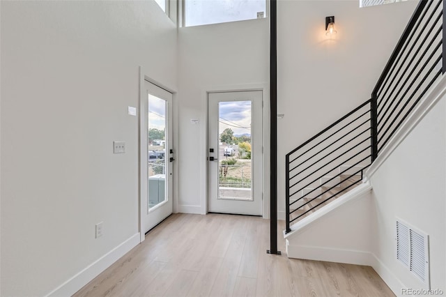 entryway with a towering ceiling and light hardwood / wood-style floors