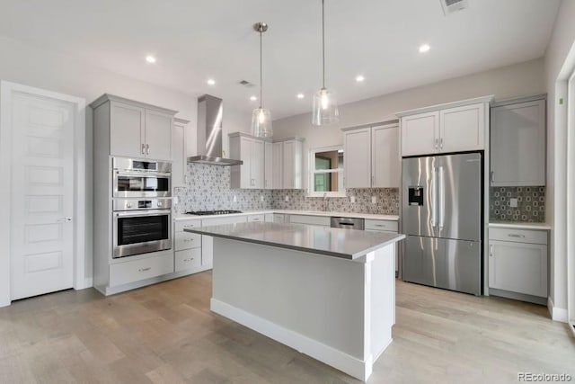 1744 Barefoot Dr, Windsor, CO 80550 - kitchen with stainless steel appliances, decorative backsplash, wall chimney exhaust hood, a center island, and light wood finished floors
