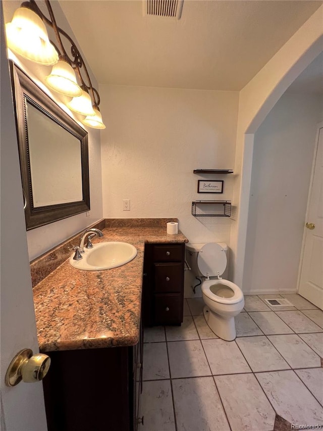 bathroom featuring vanity, toilet, and tile patterned floors