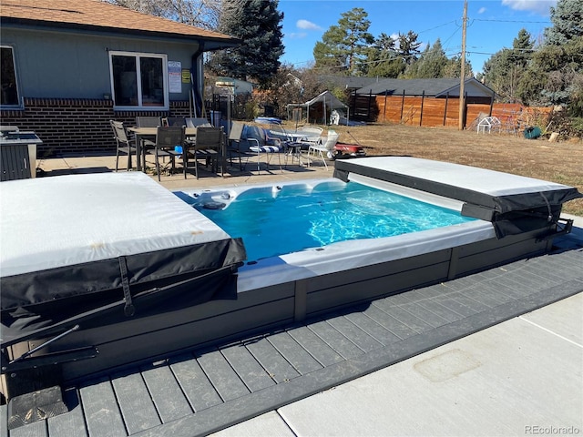 view of swimming pool featuring a covered hot tub and a patio area