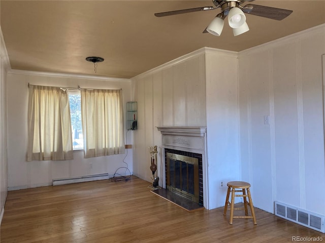 unfurnished living room featuring visible vents, a fireplace, baseboard heating, and wood finished floors