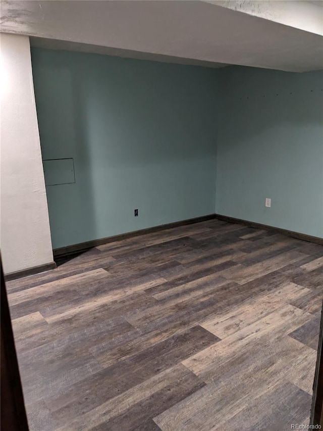 empty room with baseboards and dark wood finished floors