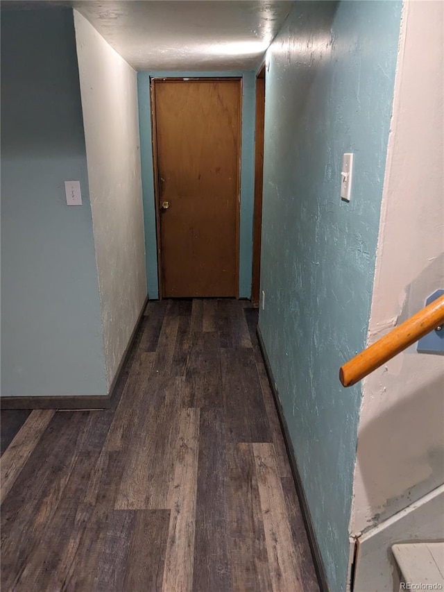 hall with baseboards, wood finished floors, and a textured wall