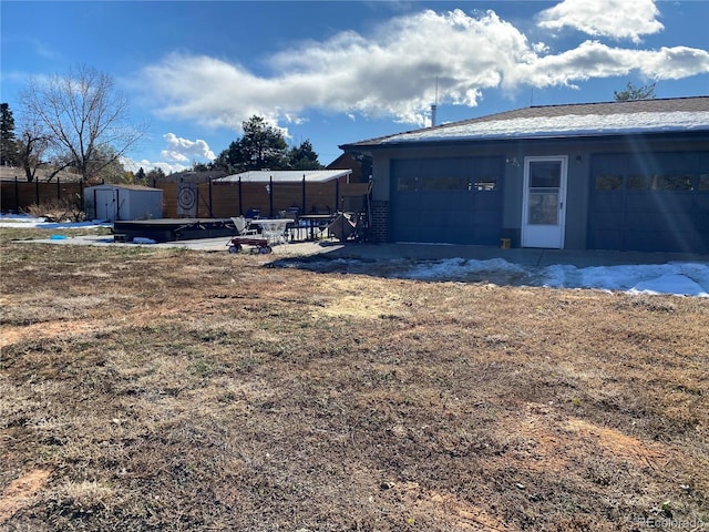 view of yard featuring an outdoor structure, a storage unit, and fence