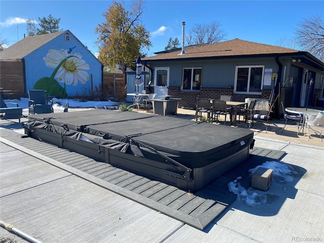 view of pool featuring a patio area, outdoor dining area, and a covered hot tub