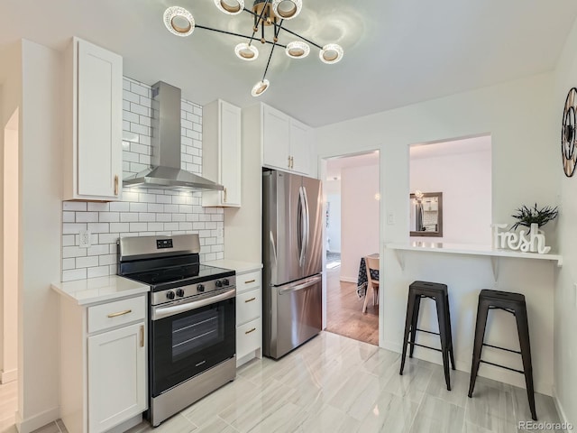 kitchen with white cabinets, wall chimney range hood, and stainless steel appliances