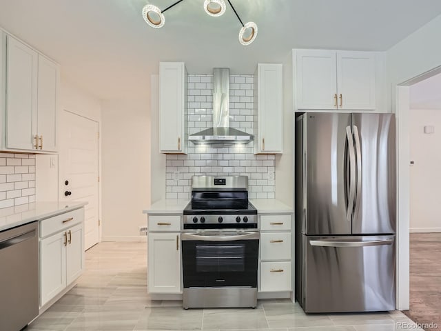 kitchen featuring white cabinets, decorative backsplash, stainless steel appliances, and wall chimney exhaust hood