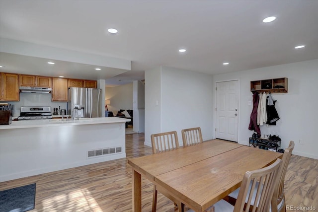 dining area featuring sink and light hardwood / wood-style floors