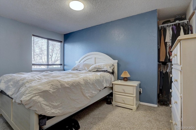 carpeted bedroom with a closet and a textured ceiling