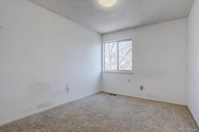 carpeted spare room featuring a textured ceiling