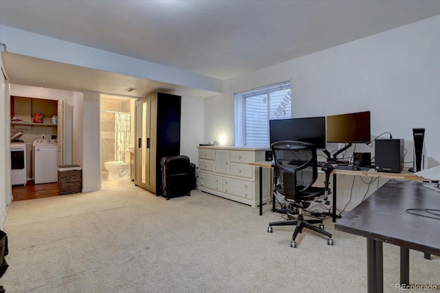 carpeted home office featuring washing machine and dryer