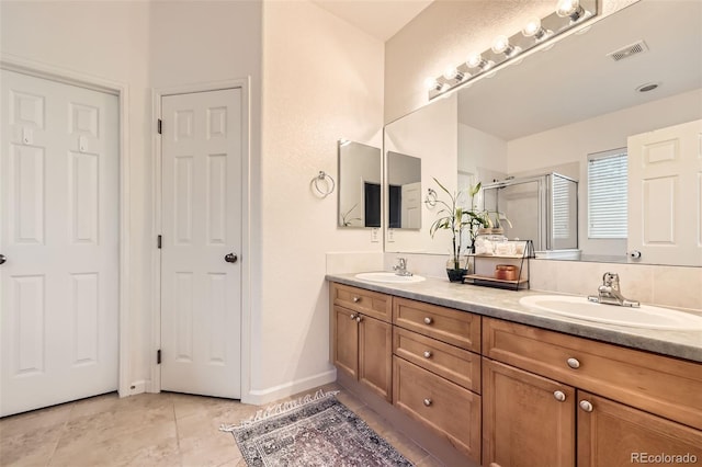 12 Apache Plume St, Brighton, CO 80601 - full bathroom with double vanity, a shower stall, and tile patterned floors