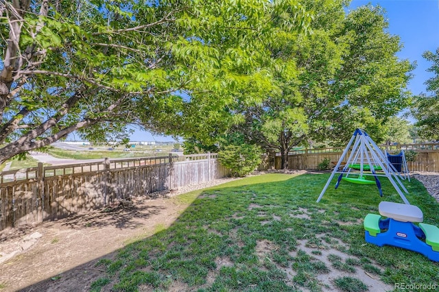 12 Apache Plume St, Brighton, CO 80601 - fenced backyard featuring a playground