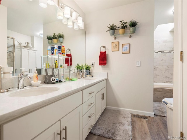 5006 S Nelson St Unit B, Littleton, CO 80127 - bathroom featuring a stall shower, wood finished floors, double vanity, and baseboards