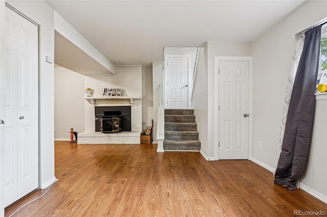 1733 S Nucla St, Aurora, CO 80017 - unfurnished living room featuring wood finished floors, stairs, and a brick fireplace