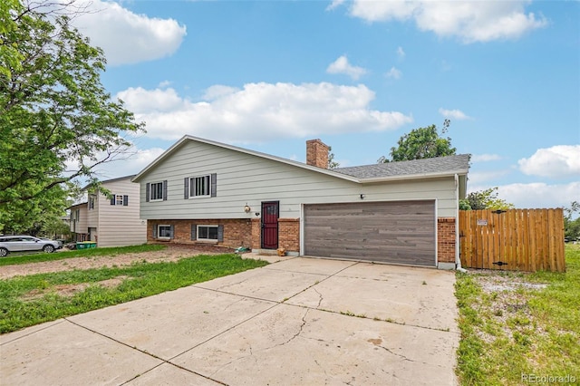 1733 S Nucla St, Aurora, CO 80017 - view of front of property featuring brick siding, concrete driveway, an attached garage, and a chimney