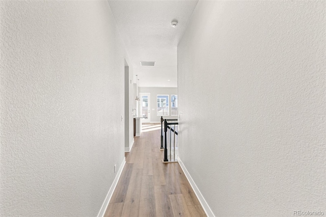 corridor with light hardwood / wood-style flooring