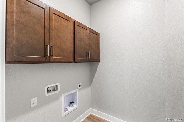 clothes washing area featuring electric dryer hookup, washer hookup, cabinets, and light wood-type flooring