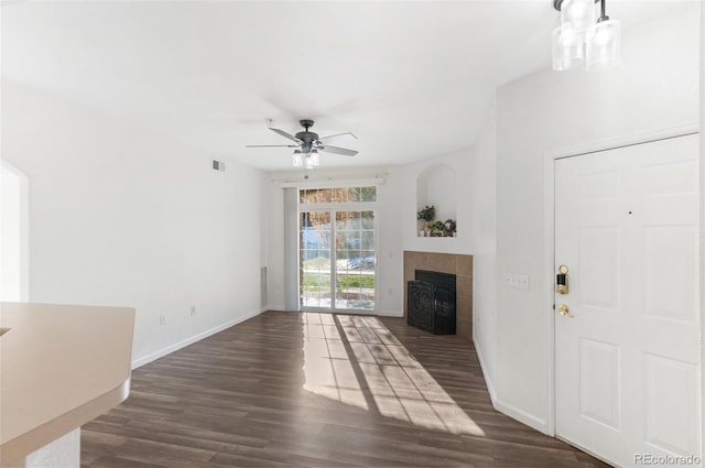 unfurnished living room featuring ceiling fan, dark hardwood / wood-style flooring, and a fireplace