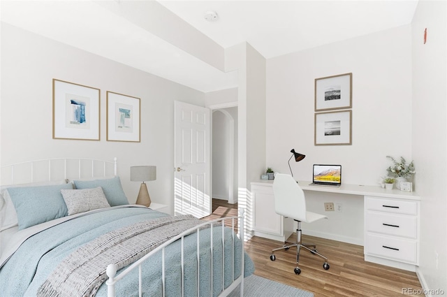 bedroom featuring built in desk and light wood-type flooring