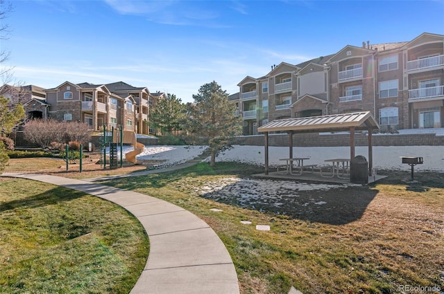 view of community featuring a gazebo, a playground, and a lawn