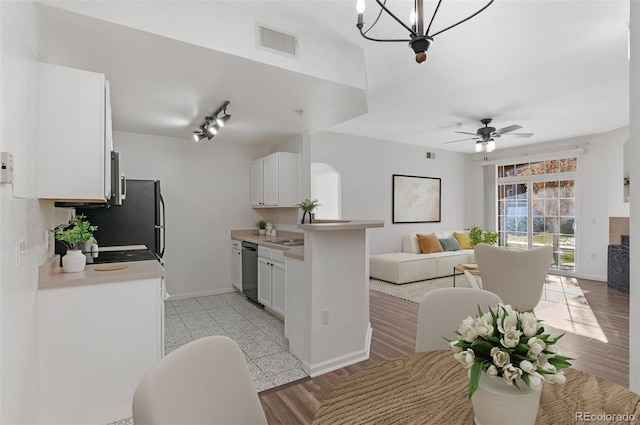 kitchen featuring white cabinetry, dishwasher, light wood-type flooring, kitchen peninsula, and ceiling fan with notable chandelier