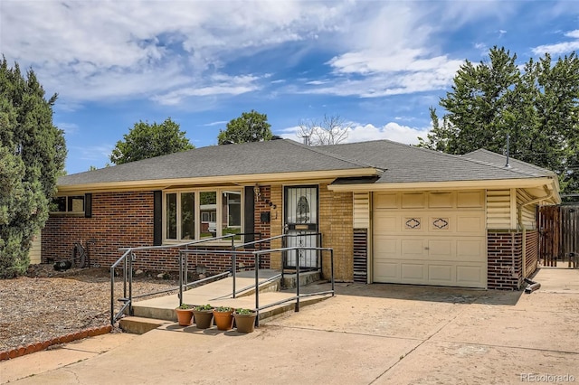 2692 S Osceola St, Denver, CO 80219 - view of front facade with brick siding, a garage, driveway, and roof with shingles