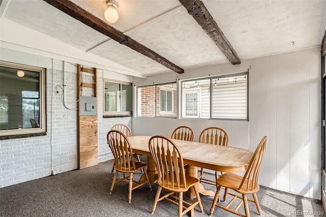 2692 S Osceola St, Denver, CO 80219 - dining room with beamed ceiling, carpet flooring, wooden walls, and brick wall
