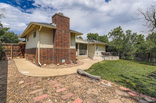 2692 S Osceola St, Denver, CO 80219 - back of property featuring a chimney, brick siding, and a patio