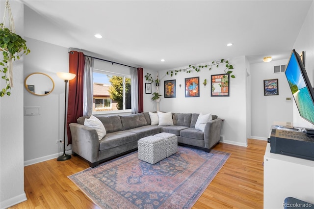 living room featuring light wood-style flooring, visible vents, baseboards, and recessed lighting