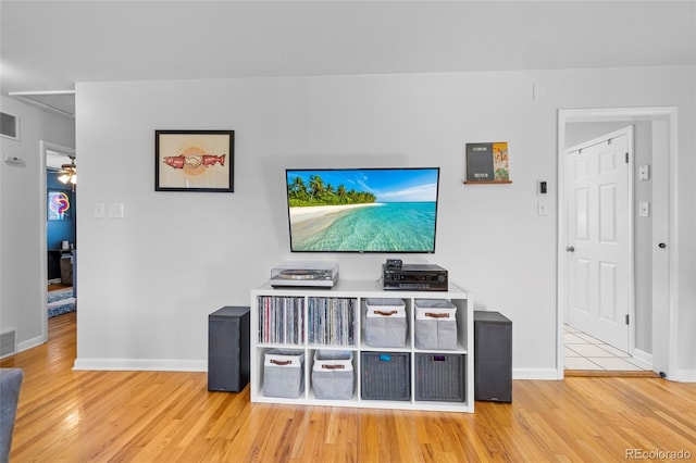 living area featuring visible vents, baseboards, and wood finished floors