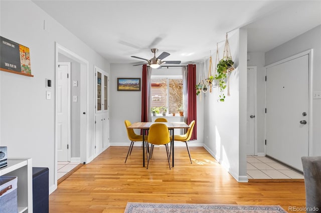 dining area featuring light wood finished floors, ceiling fan, and baseboards