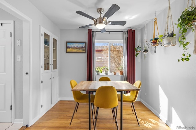 dining room featuring light wood-style floors, ceiling fan, and baseboards