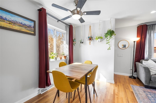 dining space with light wood-type flooring, visible vents, baseboards, and a ceiling fan