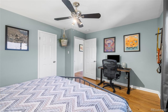 bedroom with wood finished floors, a ceiling fan, and baseboards