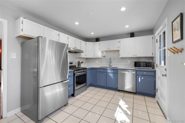 kitchen featuring blue cabinetry, stainless steel appliances, white cabinetry, a sink, and under cabinet range hood