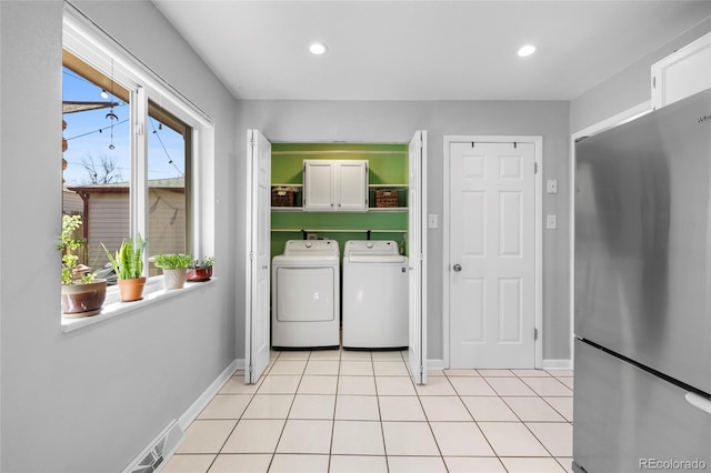 clothes washing area featuring cabinet space, light tile patterned floors, washer and clothes dryer, and recessed lighting