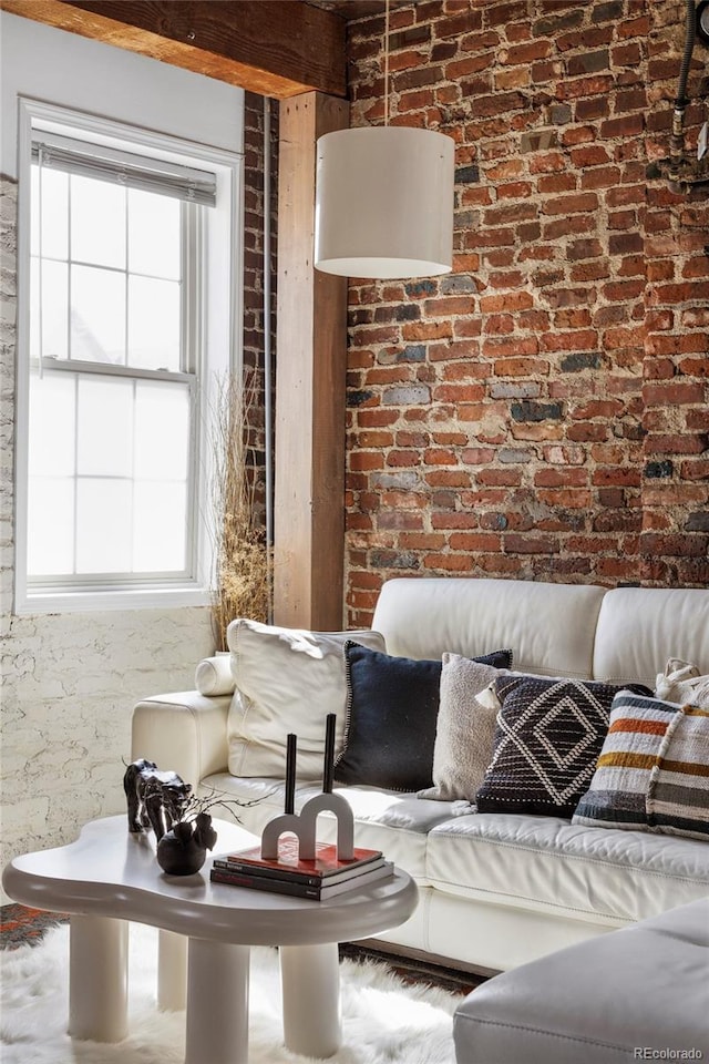living area featuring plenty of natural light and brick wall