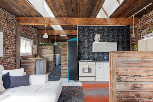 kitchen with beam ceiling, wooden ceiling, white range oven, and brick wall