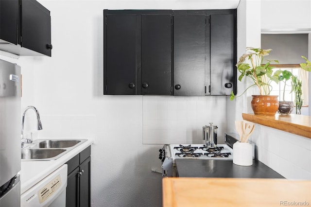 kitchen with decorative backsplash, dishwasher, a sink, light countertops, and dark cabinetry