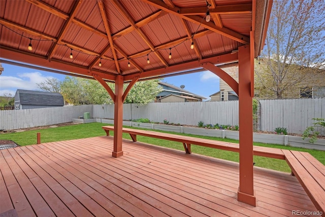 wooden deck featuring a lawn, a fenced backyard, and a gazebo