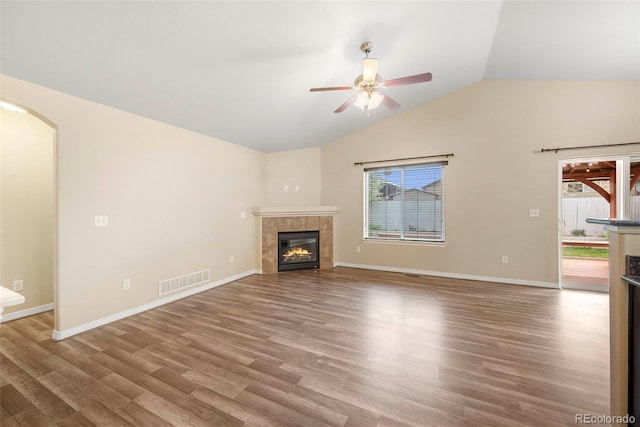 unfurnished living room featuring a ceiling fan, visible vents, lofted ceiling, and a tile fireplace
